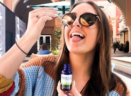 girl dropping cbd oil on tongue